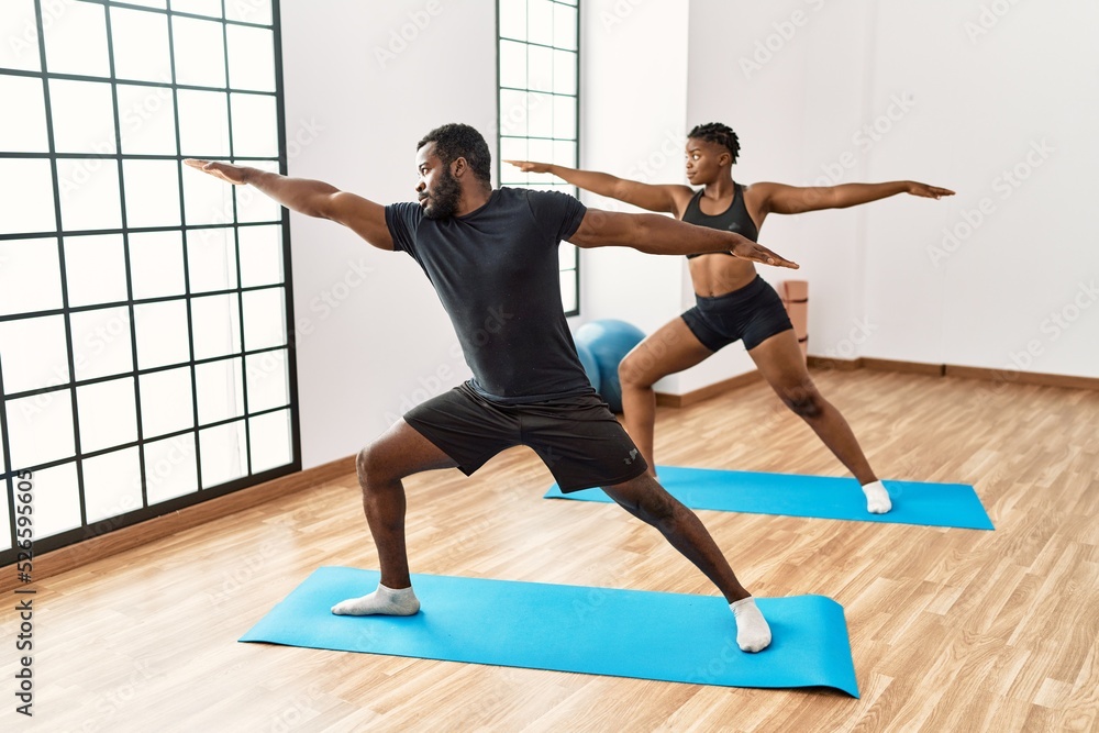 Young african american sporty couple training yoga at sport center. Young african american sporty couple training yoga at sport center.