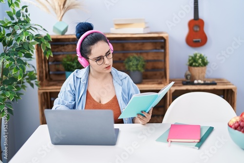 Young caucasian woman sitting on table studying at home