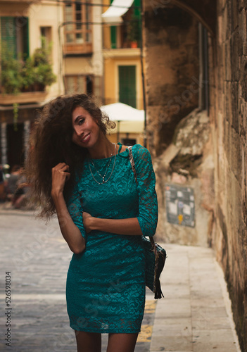 Cute charming girl, Spain, Mallorca. Cinematic Processing. Attractive brunette with curly hair woman, Palma, Mallorca (Majorca) Street fashion.