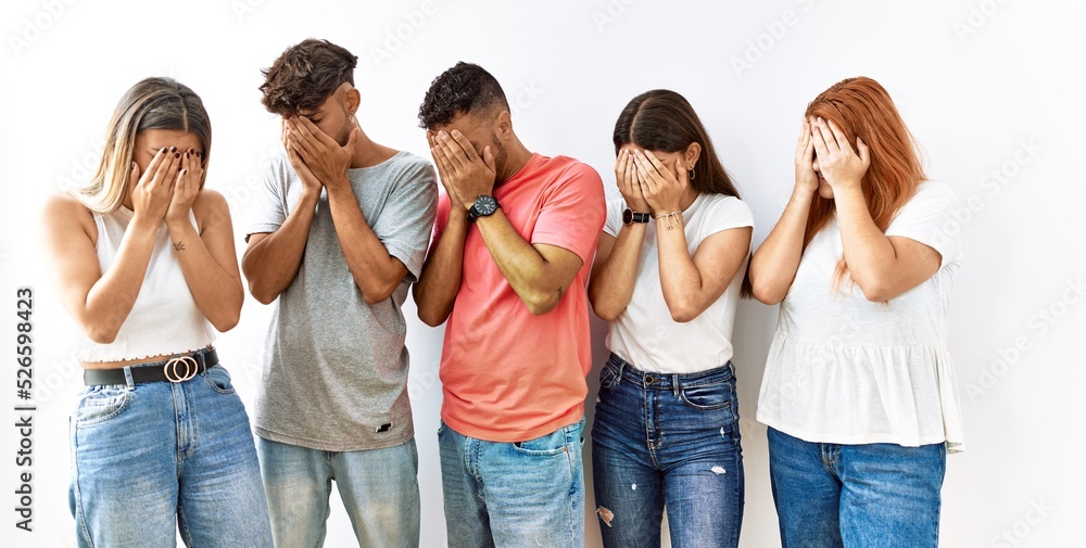 Group of young friends standing together over isolated background with sad expression covering face with hands while crying. depression concept. Group of young friends standing together over isolated background with sad expression covering face with hands while crying. depression concept.