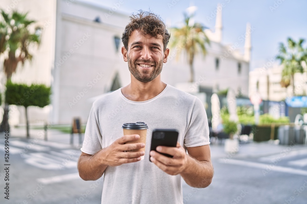 Young hispanic man using smartphone drinking coffee at street Young hispanic man using smartphone drinking coffee at street