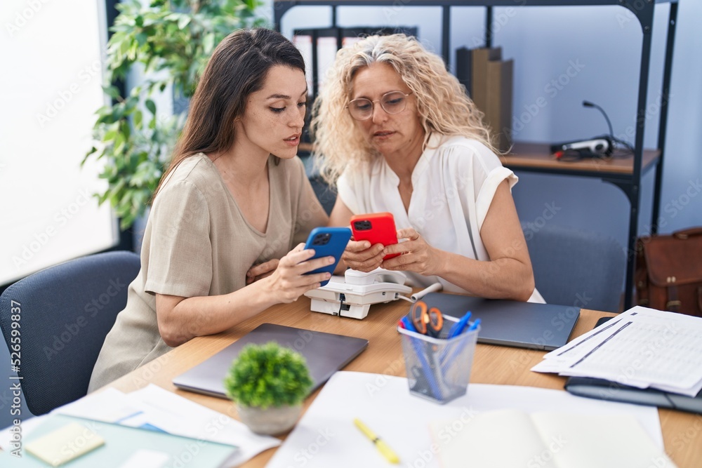 Fototapeta premium Two women business workers using smartphone working at office