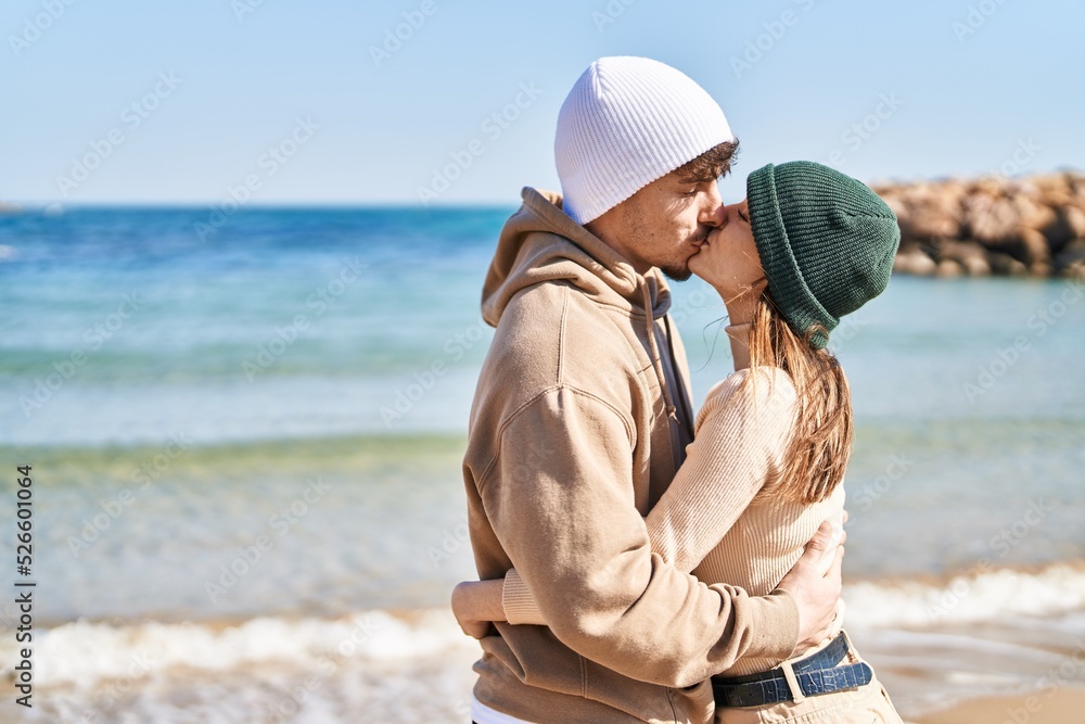 Mand and woman couple hugging each other and kissing at seaside
