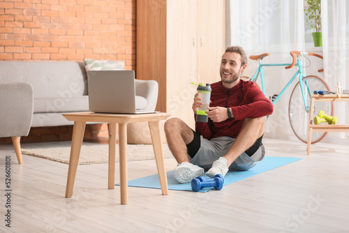 Sporty young man drinking w...