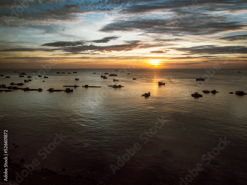 Fototapeta Naklejka Na Ścianę i Meble -  Beautiful top view of the sea at sunset with fisher boats in Vietnam