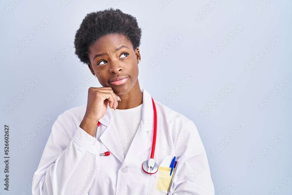 African american woman wearing doctor uniform and stethoscope serious face thinking about question with hand on chin, thoughtful about confusing idea African american woman wearing doctor uniform and stethoscope serious face thinking about question with hand on chin, thoughtful about confusing idea
