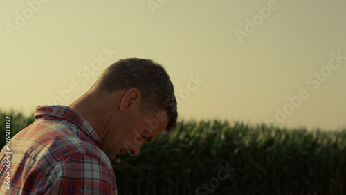 Valokuva Thoughtful farmer walking field in morning sunlight closeup