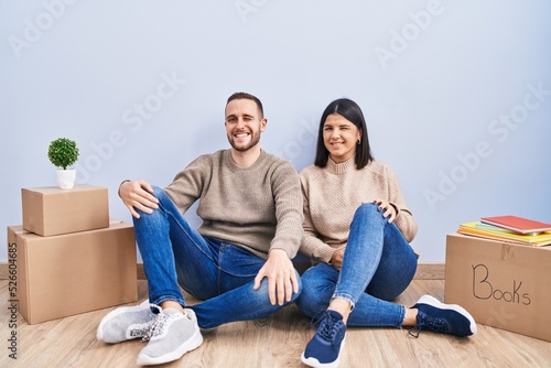 Young couple moving to a new home winking looking at the camera with sexy expression, cheerful and happy face. © Krakenimages.com