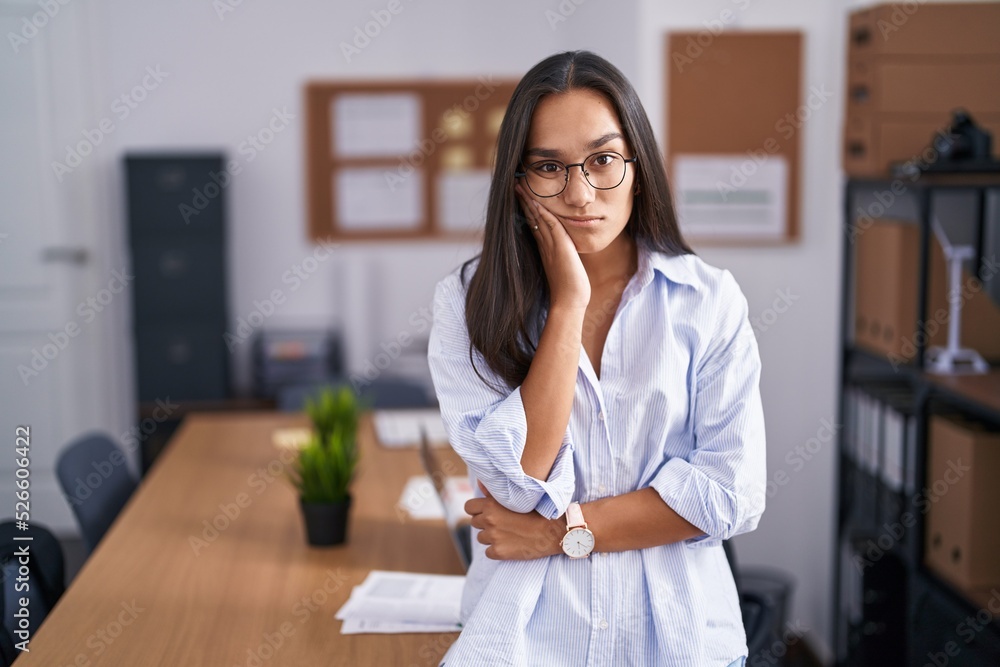 Young hispanic woman at the office thinking looking tired and bored with depression problems with crossed arms. Young hispanic woman at the office thinking looking tired and bored with depression problems with crossed arms.