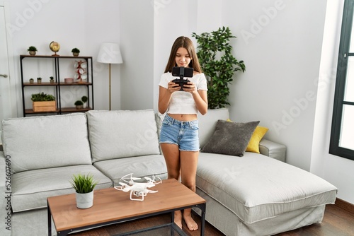 Adorable girl smiling confident using drone at home