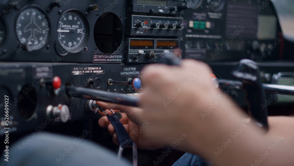 Pilot starting airplane engine using key sitting in modern plane cabin closeup.