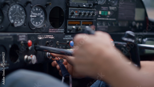 Pilot starting airplane engine using key sitting in modern plane cabin closeup.