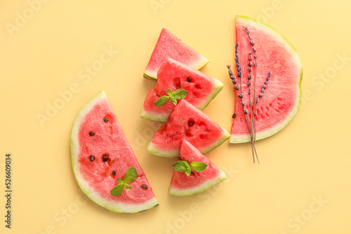 Slices of watermelon with mint and flowers on color background