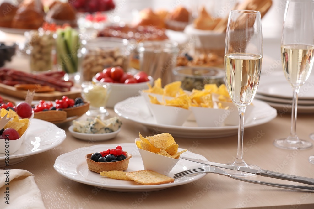 Variety of snacks on wooden table in buffet style indoors Variety of snacks on wooden table in buffet style indoors
