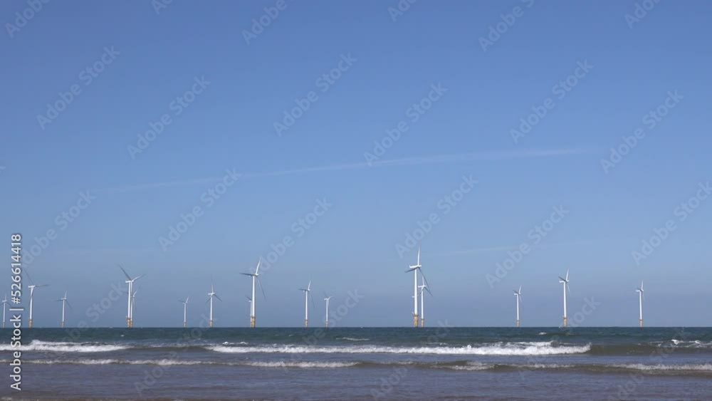 Offshore wind turbines for green energy to make carbon neutral waves on the sea for climate change. View from the beach shoreline UK 4K Offshore wind turbines for green energy to make carbon neutral waves on the sea for climate change. View from the beach shoreline UK 4K