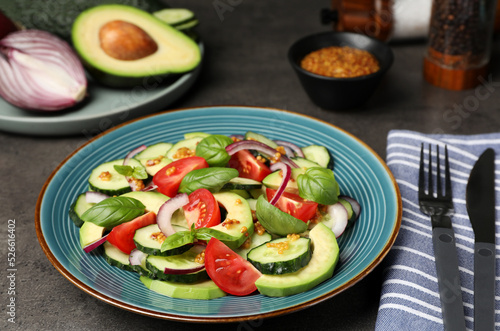 Tasty salad with cucumbers served on grey table