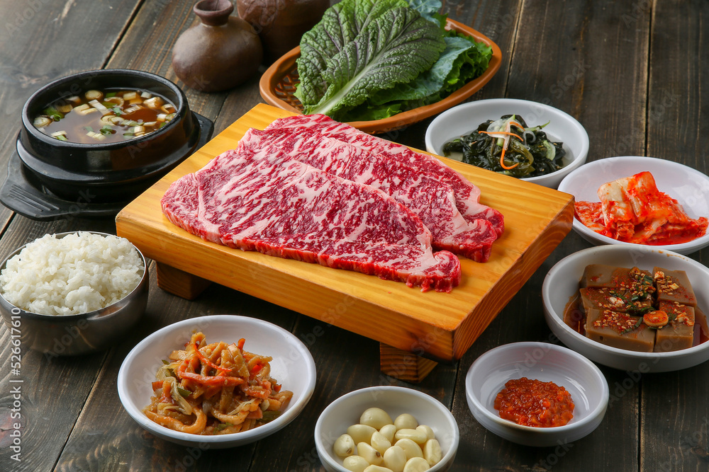 Beef chuck flap tail and side dishes in the background 나무배경에 소고기 살치살과 밑반찬들