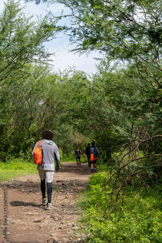 two young men and friends descending in the ravine, vegetation and trees, huentitan ravine guadalajara, mexico © rodrigo