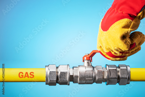 Opening or closing the gas pipeline gate. Male hand in yellow glove opens or closes gas valve on gas pipe. Copy space.
