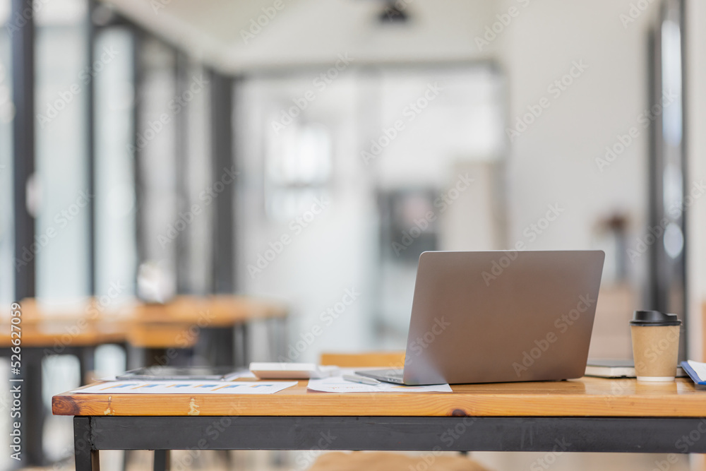 Laptop Computer, notebook, and eyeglasses sitting on a desk in a large open plan office space after working hours
Laptop Computer, notebook, and eyeglasses sitting on a desk in a large open plan office space after working hours