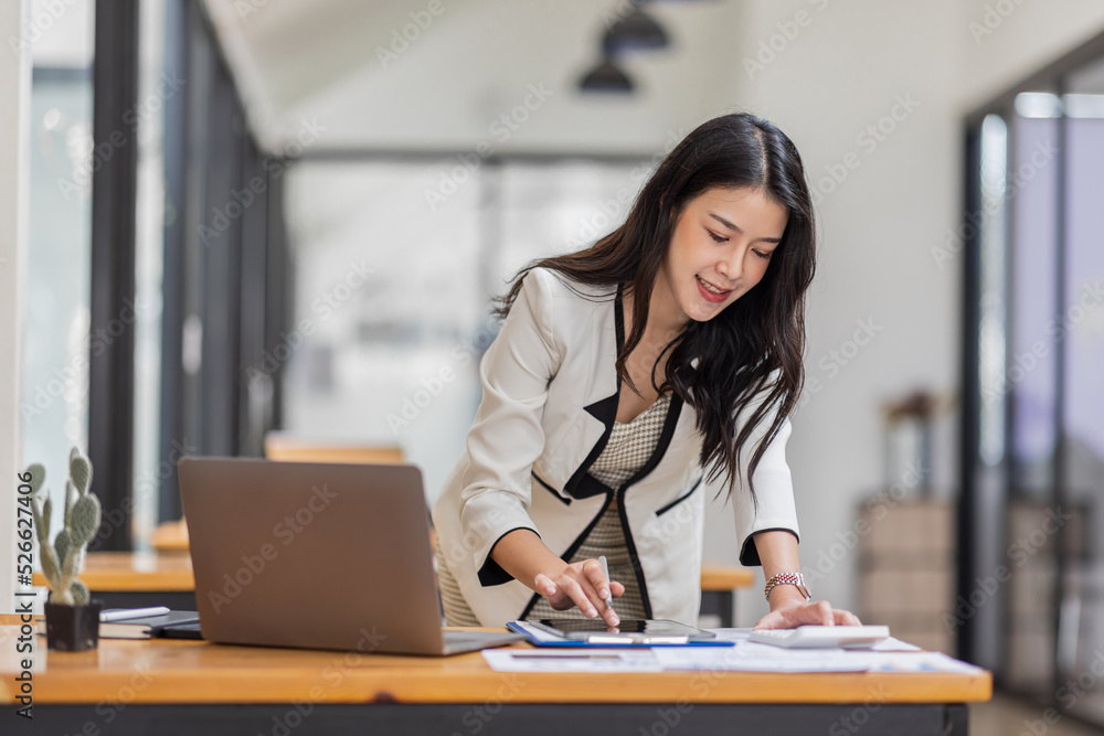Female Business Asian working on documents on tablet laptop in the workplace, Young asian woman sitting at table doing planning financial report, business plan investment, finance analysis concept. Female Business Asian working on documents on tablet laptop in the workplace, Young asian woman sitting at table doing planning financial report, business plan investment, finance analysis concept.