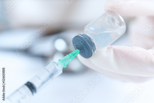 バイアル瓶から注射薬を吸う医師の手元 photo