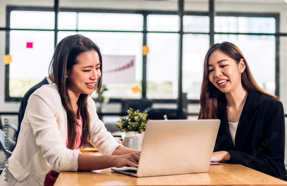 Obraz premium Asian two business woman meeting analyzing and discussing strategy with startup project.Creative business people plan and brainstorm with desktop computer on conference in office.Teamwork