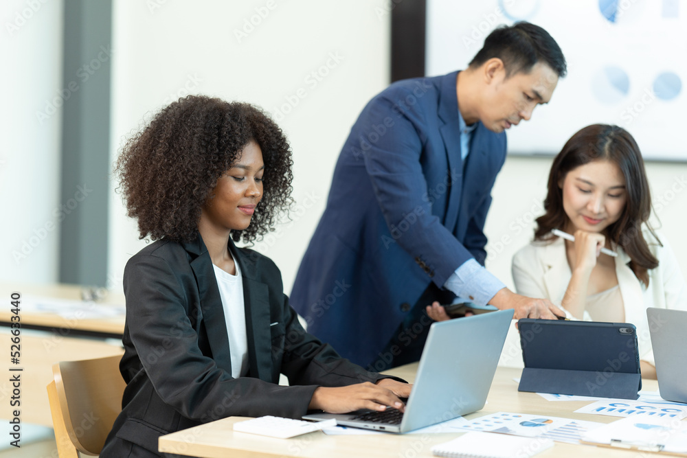 Business people showing team work while working in board room in office interior. People helping one of their colleague to finish new business plan. Business concept. Team work. Business people showing team work while working in board room in office interior. People helping one of their colleague to finish new business plan. Business concept. Team work.