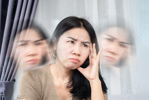 Obraz na plátně Asian woman suffering from dizziness hand holding her headache and vertigo