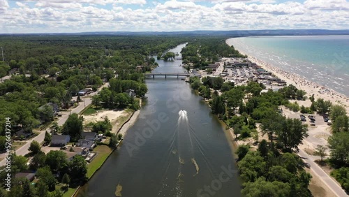 Jet Ski in wasaga beach coastline with blue waters and boats and people on beach photo