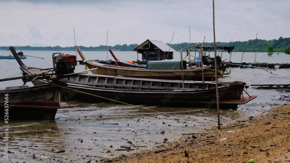 Fishing boats moored in a local fishing jetty on Yao Yai Island, Phang Nga, Thailand. fishing boats at the beach and waves. Fishing boats moored in a local fishing jetty on Yao Yai Island, Phang Nga, Thailand. fishing boats at the beach and waves.