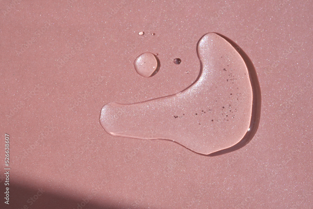 Fototapeta premium A drop of cosmetics or perfume on a pink background.