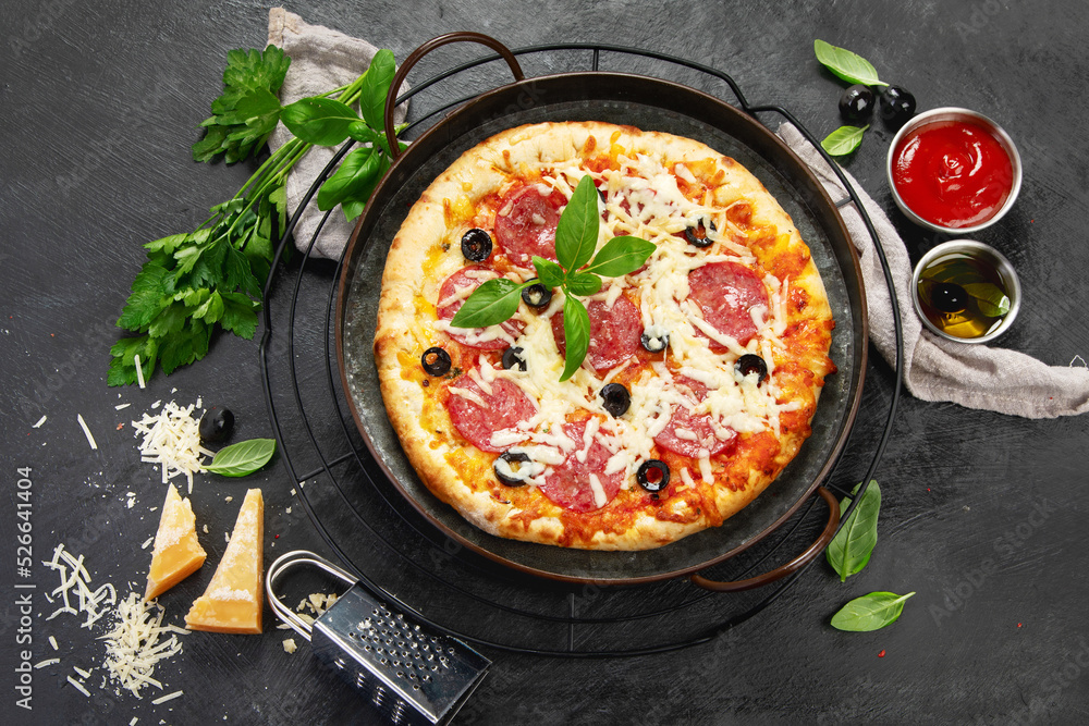 Freshly baked pepperoni pizza on dark background. Freshly baked pepperoni pizza on dark background.