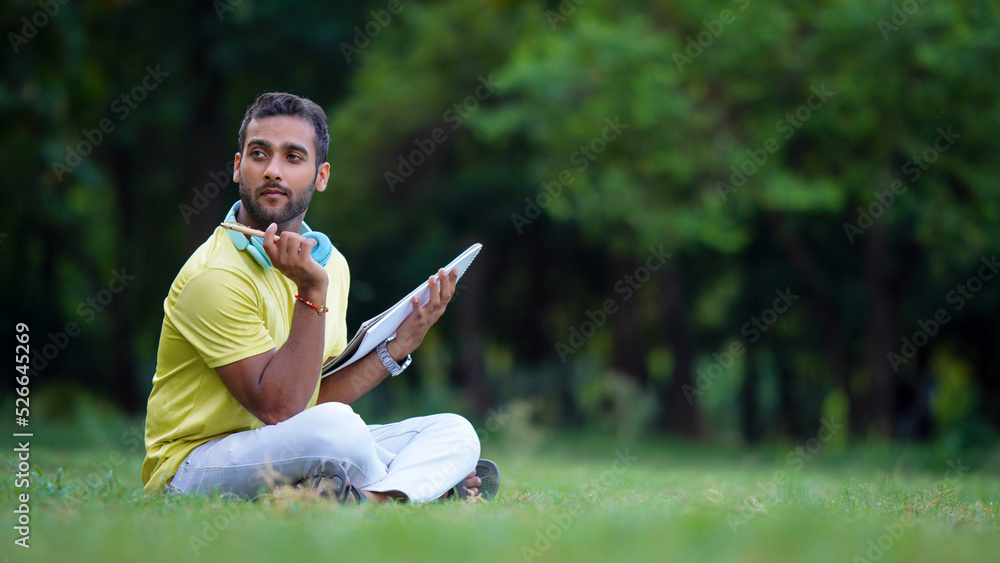 Obraz premium student sitting on the grass thinking something