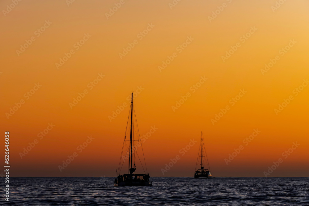 Sea yachts against the background of the sun reflected in the waves
