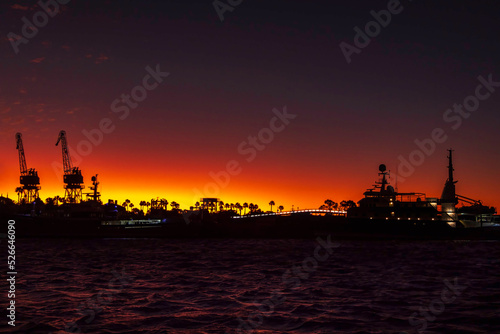 Cape Town Port sharply silhouetted against the bold orange and pink colors of a sunset sky
