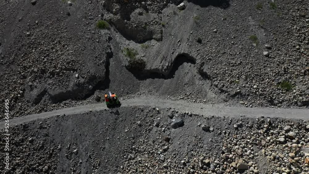Cinematic downward angle drone shot of a Tuk Tuk driving on a small gravel path in the Gojal valley upper Hunza of the Gilgit Baltistan, Pakistan Cinematic downward angle drone shot of a Tuk Tuk driving on a small gravel path in the Gojal valley upper Hunza of the Gilgit Baltistan, Pakistan