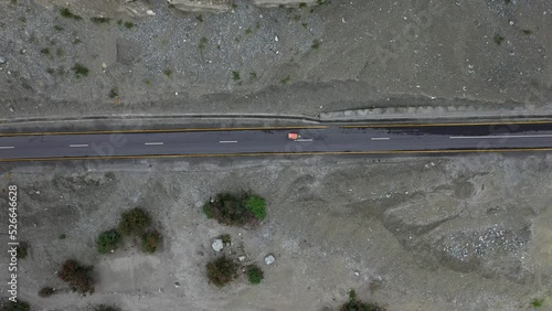 Downward angle drone shot of a tuk tuk driving on a highway in Pakistan photo