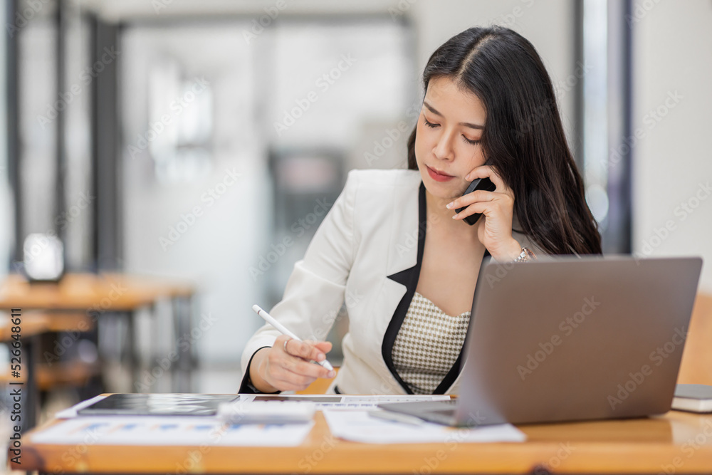 Obraz premium Professional young business asian woman using computer laptop and Talking On Phone and work On Laptop in the workplace Modern Office.