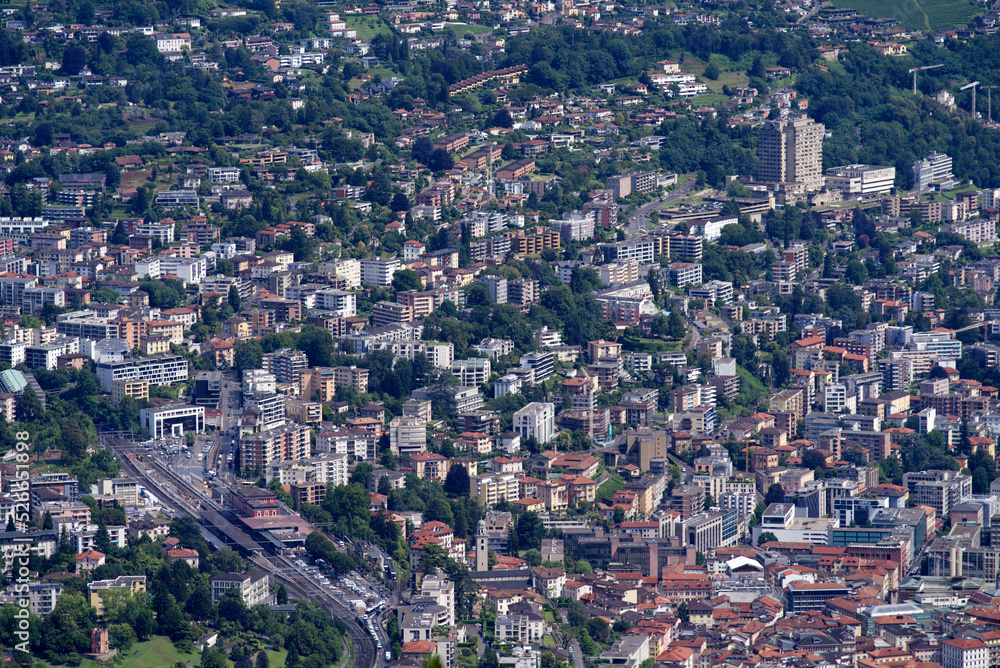 Aerial view of City of Lugano seen from local mountain San Salvatore on a cloudy summer day. Photo taken July 4th, 2022, Lugano, Switzerland.