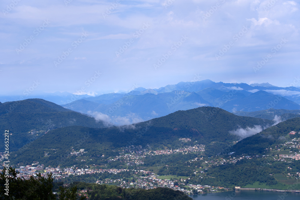 Aerial scenic view over region of Lugano, Canton Ticino, on a cloudy summer day. Photo taken July 4th, 2022, Lugano, Switzerland.