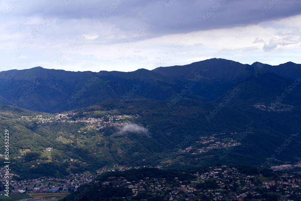Aerial view of scenic landscape seen from local mountain San Salvatore on a cloudy summer day. Photo taken July 4th, 2022, Lugano, Switzerland. Aerial view of scenic landscape seen from local mountain San Salvatore on a cloudy summer day. Photo taken July 4th, 2022, Lugano, Switzerland.