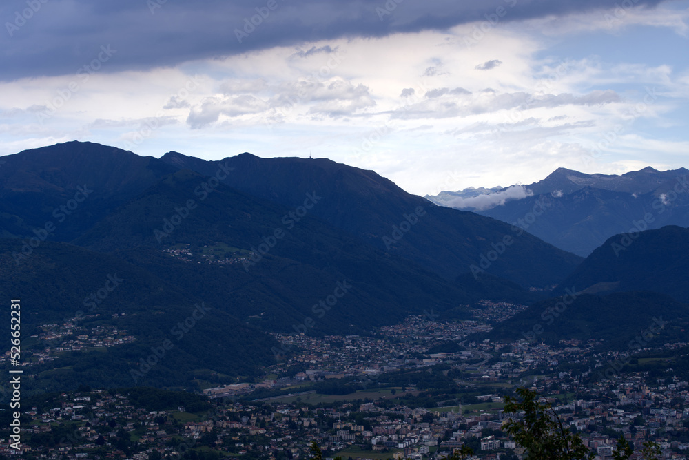 Aerial view of scenic landscape seen from local mountain San Salvatore on a cloudy summer day. Photo taken July 4th, 2022, Lugano, Switzerland.