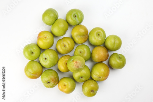 Small mini green fresh juicy plum fruit on white background cut slice half seed many pile
