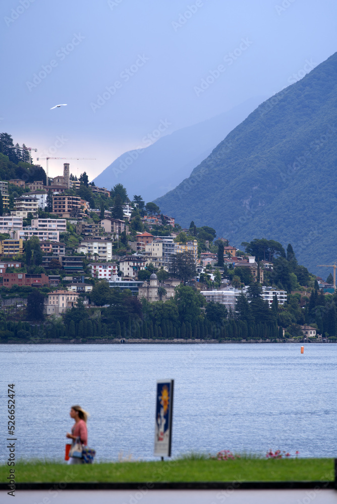 Lake Lugano with local mountain Monte Brè in the background on a cloudy summer day. Photo taken July 4th, 2022, Lugano, Switzerland.
