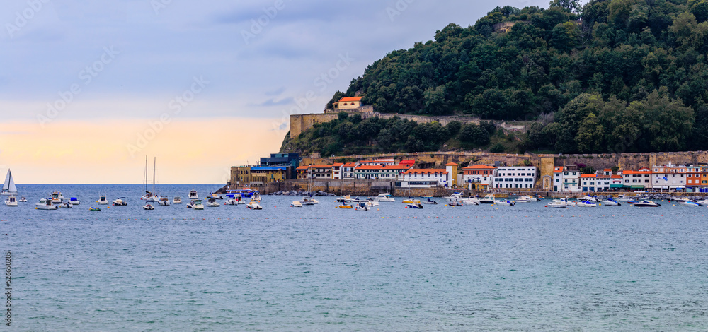 Panoramic view of La Concha bay and mount Urgull, San Sebastian Donostia at sunset with the city coastline and waterfront homes, Basque Country, Spain