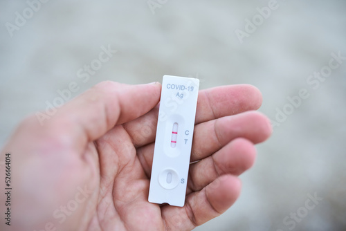 Fotografie Close up hand holding rapid covid -19 test with a positive result outdoor