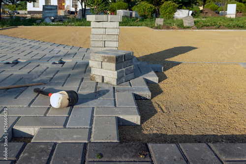 Paving the garden path with bricks. Laying concrete paving slabs in the courtyard of the house on a sandy foundation