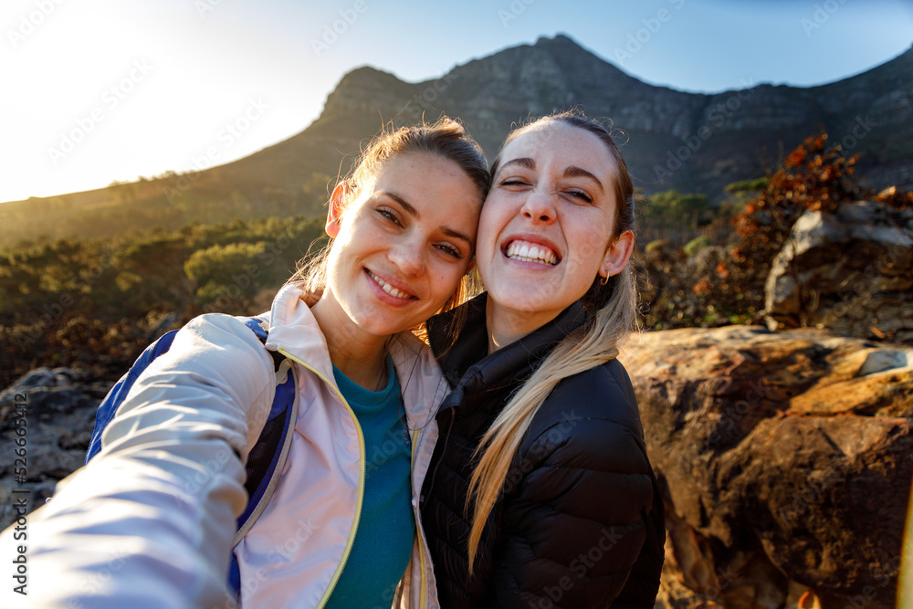 Portrait of cheerful friends hiking against mountain