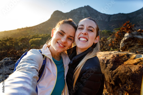 Portrait of cheerful friends hiking against mountain